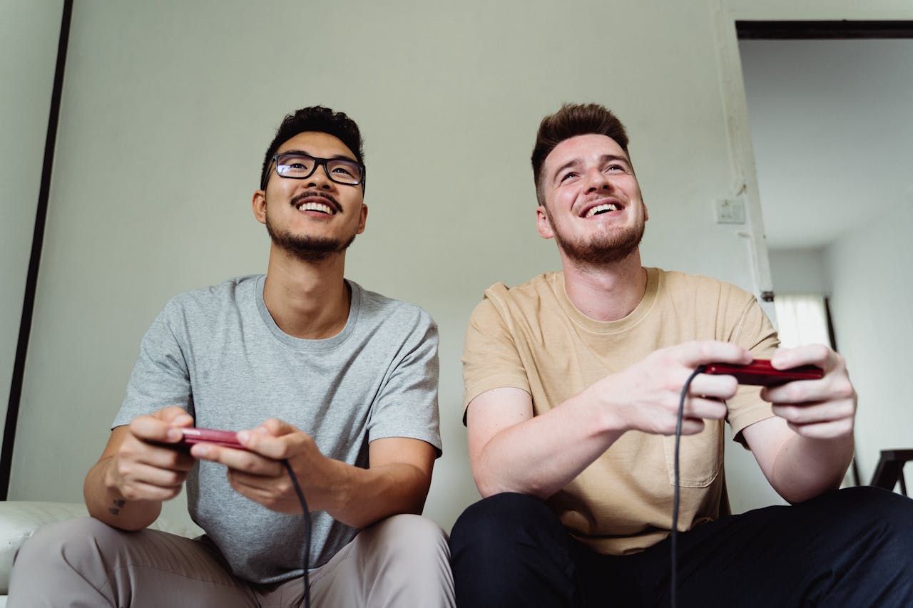 Two men happily playing video games in a modern living room.